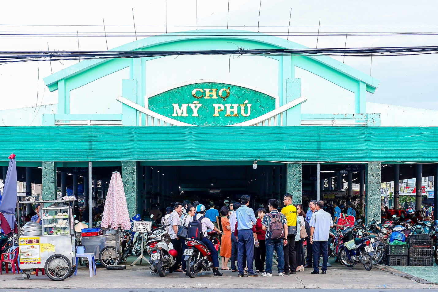 A group of people standing in front of a buildingDescription automatically generated