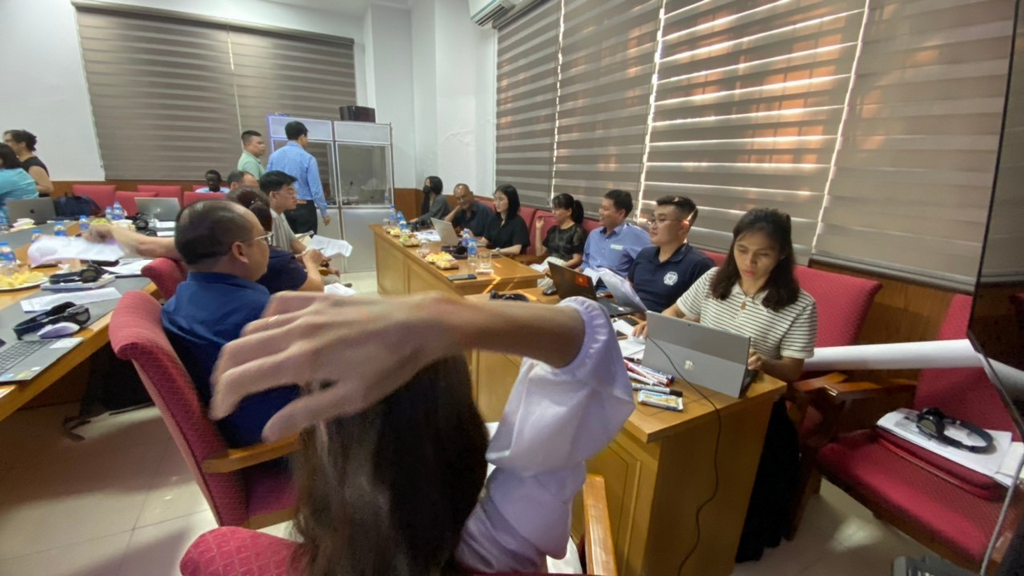 A group of people sitting at desks in a classroomDescription automatically generated